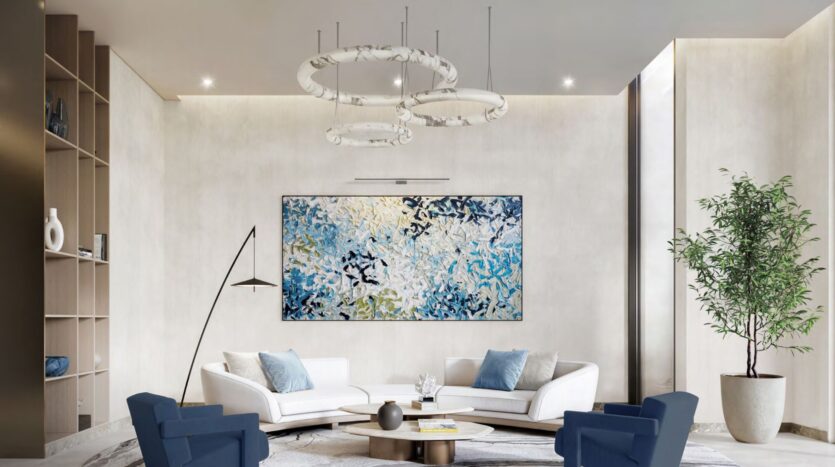Le salon moderne de Windsor House de Ellington Properties présente des murs blancs, des fauteuils bleus, des canapés blancs, des œuvres d'art abstraites bleues, une table basse circulaire, un lampadaire, une plante haute et des lampes suspendues circulaires.