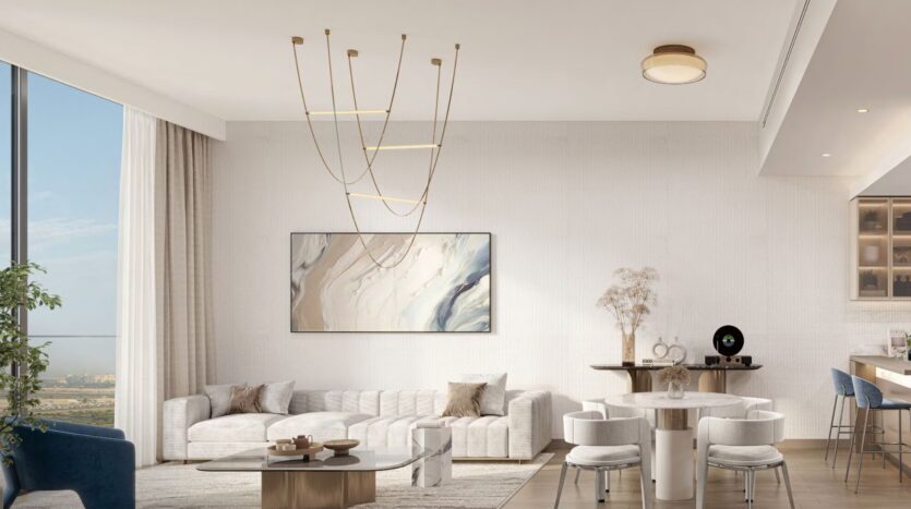 Salon et salle à manger modernes à Windsor House de Ellington Properties avec une grande fenêtre, un canapé blanc, un tableau mural abstrait, une table à manger ronde avec des chaises bleues et un éclairage élégant. Les tons neutres et le décor minimaliste créent une atmosphère lumineuse et aérée.
