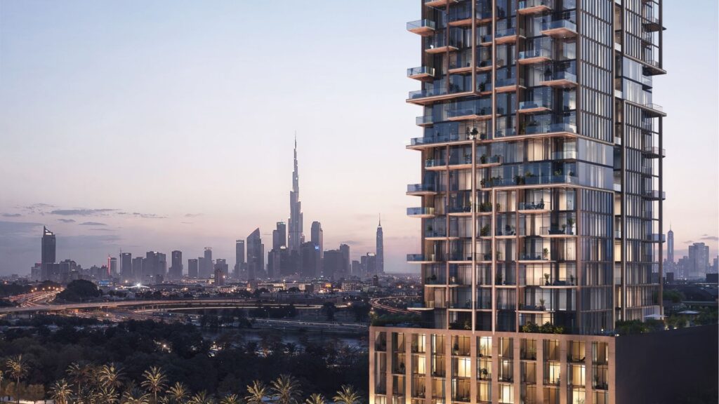 Modern high-rise building with glass balconies in the foreground; Dubai skyline and Burj Khalifa visible in the background at sunset, illustrating the distinctive style of Wynwood Horizon by Imtiaz.