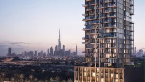 Moderno grattacielo con balconi in vetro in primo piano; lo skyline di Dubai e il Burj Khalifa visibili sullo sfondo al tramonto, illustrano lo stile distintivo di Wynwood Horizon di Imtiaz.