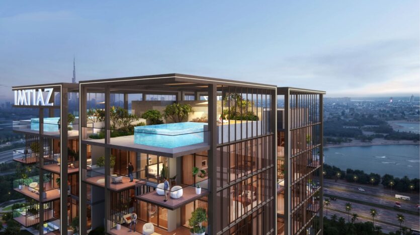 L'immeuble moderne de grande hauteur Wynwood Horizon de Imtiaz est doté de jardins sur les toits et d'une piscine en verre surélevée, donnant sur un paysage urbain avec une rivière, des routes et des gratte-ciel lointains au coucher du soleil.