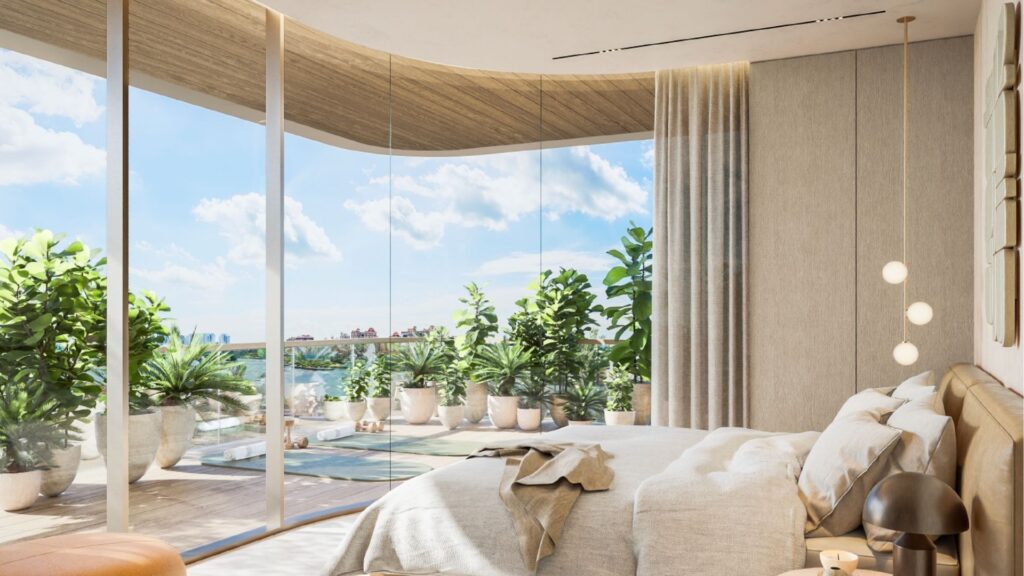 A modern room at Avida Residences Dubai Islands with floor-to-ceiling glass windows overlooking a balcony filled with potted plants. The room features a well-made bed, neutral tones, natural sunlight and minimalist decor.
