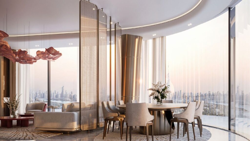 Un moderno y lujoso salón-comedor en el Binghatti Skyblade con ventanas curvas de suelo a techo, mobiliario elegante, toques dorados y vistas de la ciudad al atardecer. Sillones de felpa, una mesa redonda e iluminación decorativa crean un ambiente sofisticado.