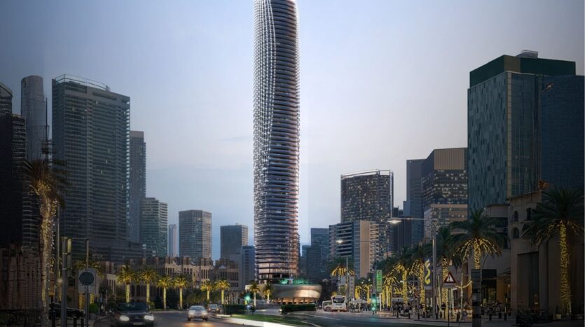 El Binghatti Skyblade, un gran rascacielos moderno con un diseño curvo único, destaca entre otros rascacielos en un paisaje urbano, con palmeras y farolas que bordean una concurrida calle al atardecer.