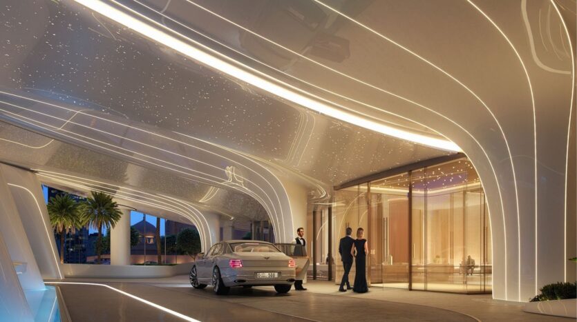 Un coche de lujo se detiene frente a la entrada futurista del Binghatti Skyblade, con su arquitectura curva, sus luces brillantes y la gente vestida de etiqueta junto a las puertas de cristal. Las palmeras se mecen frente a este moderno monumento.