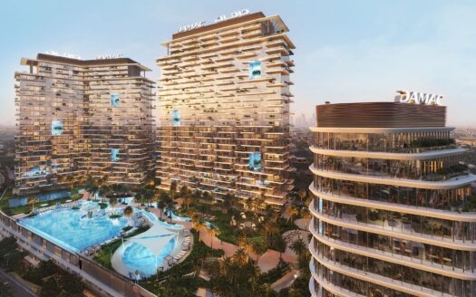 A modern complex of high-rise buildings with unique staggered balconies, featuring a large central swimming pool surrounded by palm trees. Located in Dubai's Damac district, the buildings bear the "DAMAC" logo and overlook a sunset cityscape.