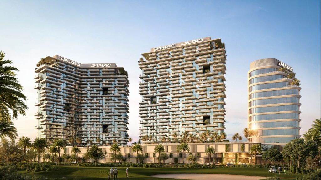 Tres modernas torres con balcones y zonas verdes, situadas en el Damac District Dubai, se elevan sobre palmeras y un campo de golf bajo cielos despejados. Los edificios están coronados por un prominente letrero "DAMAC".