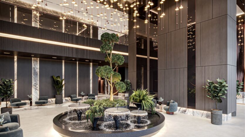 Le hall d'entrée de l'hôtel est moderne, avec de hauts murs sombres, une fontaine circulaire centrale entourée de plantes vertes, d'élégantes lampes suspendues et d'élégants fauteuils. Découvrez un confort raffiné inspiré par Sierra by Iman.