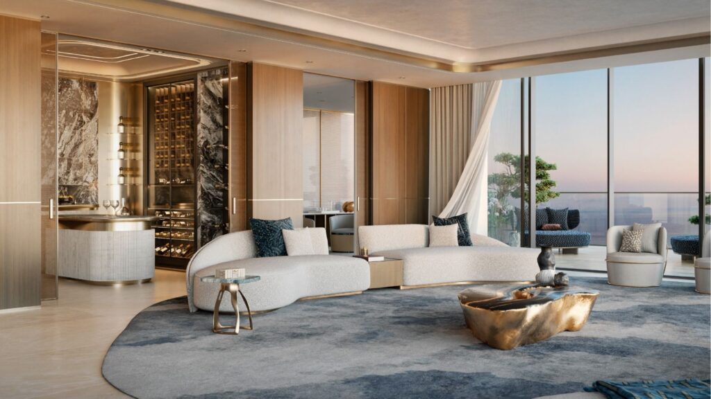 Le luxueux salon moderne du Silena Dubai Islands est doté de fenêtres allant du sol au plafond, de canapés blancs incurvés, d'éléments en marbre, d'une table basse sculpturale, d'un tapis bleu-gris moelleux et d'un bar encastré, le tout donnant sur une vue époustouflante de la ligne d'horizon et de l'eau.