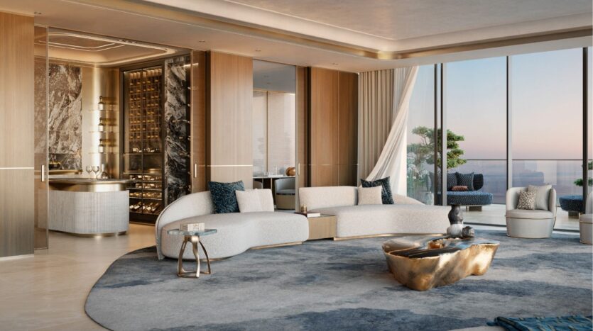 Le luxueux salon moderne du Silena Dubai Islands est doté de fenêtres allant du sol au plafond, de canapés blancs incurvés, d'éléments en marbre, d'une table basse sculpturale, d'un tapis bleu-gris moelleux et d'un bar encastré, le tout donnant sur une vue époustouflante de la ligne d'horizon et de l'eau.