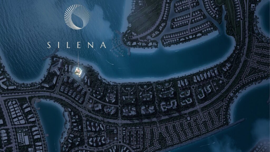 Une vue aérienne nocturne des îles Silena de Dubaï montre des bâtiments en bord de mer, des routes et des voies navigables. Le mot "SILENA" et un logo circulaire apparaissent en évidence sur l'image, soulignant l'emplacement d'un bâtiment spécifique.
