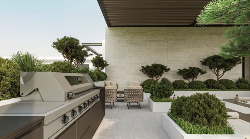 Terrasse moderne avec un grand gril en acier inoxydable au premier plan, entouré d'arbustes verts, de plantes en pot et d'un coin salon avec des chaises rembourrées et une table sous une pergola.