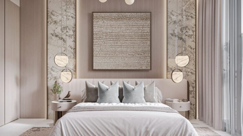 Chambre à coucher moderne avec un grand lit, une literie neutre, quatre oreillers gris, des accents muraux en marbre, des lampes suspendues rondes de chaque côté, des tables d'appoint et une grande œuvre d'art abstraite au-dessus de la tête de lit. Des rideaux encadrent une fenêtre sur la droite.
