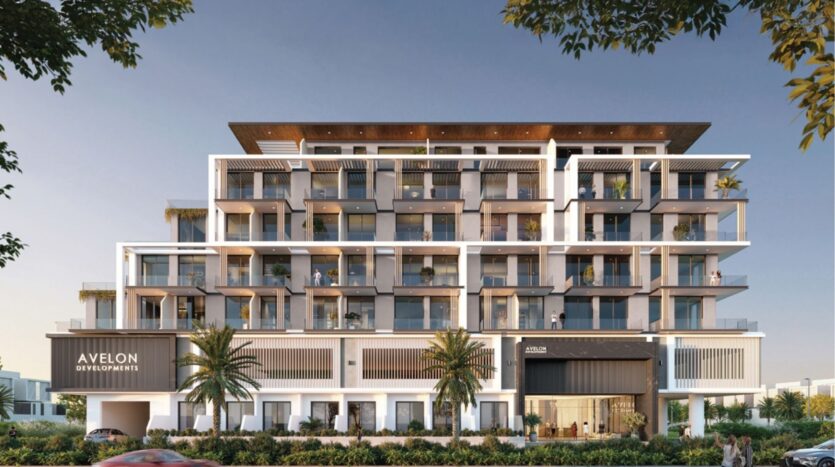 Immeuble moderne d'appartements de moyenne hauteur avec de nombreux balcons, de grandes fenêtres et des palmiers à l'avant. L'immeuble présente une enseigne "Avelon Developments" et une entrée élégante, sous un ciel bleu limpide.