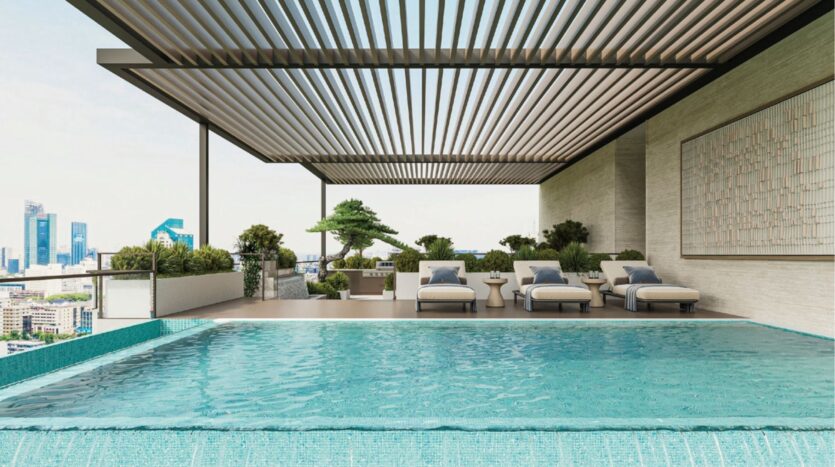 Piscine à débordement à l'eau bleue claire sur un toit-terrasse, ombragée par une pergola moderne à lamelles. Plusieurs chaises longues, des plantes en pot et des bâtiments de la ville sont visibles à l'arrière-plan.