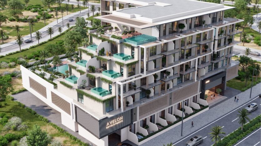 Un immeuble moderne de plusieurs étages avec des jardins sur les toits, des piscines privées sur les balcons, de grandes fenêtres et de la verdure autour de la propriété. Des voitures sont garées dans la rue et des arbres bordent les routes avoisinantes.