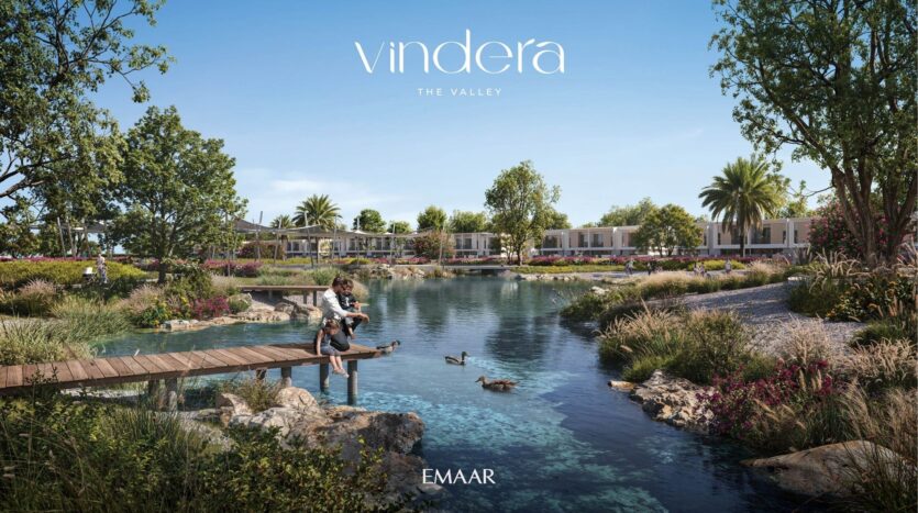 A landscaped residential community with modern villas, lush vegetation, a clear pond, ducks, and a father with a child sitting on a wooden pier. The sky is clear and "vendera, THE VALLEY, EMAAR" is written across the top.