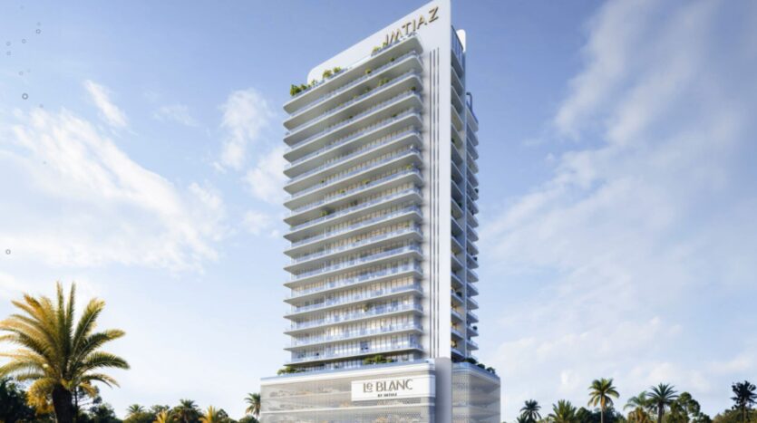 Une tour moderne baptisée "Metaz" et "Le Blanc", avec des balcons blancs et des fenêtres en verre, s'élève sur fond de ciel bleu et de palmiers, mettant en valeur l'élégance contemporaine de la Résidence Le Blanc à Dubailand.