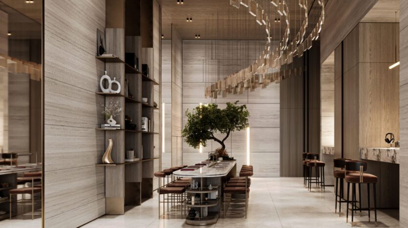 La salle à manger moderne et élégante de la Résidence Le Blanc à Dubailand se compose d'une longue table, de chaises en cuir, d'un arbre en guise de pièce maîtresse, d'étagères allant du sol au plafond, d'un éclairage chaleureux et d'un décor minimaliste dans des tons neutres. Des luminaires incurvés sont suspendus au plafond.