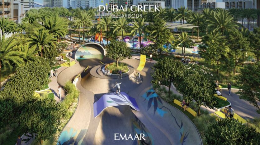 Un vivace skatepark con rampe tortuose e verde, circondato da palme e strutture colorate nel porto di Dubai Creek, vicino al Lyvia by Palace Residence. Sullo sfondo si ergono edifici moderni. Il testo recita "Dubai Creek Harbour" e "EMAAR".
