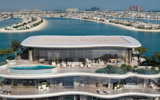A luxurious rooftop penthouse at Maison Margiela Residences features a pool and outdoor seating, overlooking the sea and the islands of Palm Jumeirah in Dubai. Modern design and panoramic ocean views define this exclusive getaway.