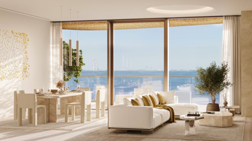 Гостиная и столовая в Maison Margiela Residences - современная и элегантная, с белой мебелью, золотыми акцентами и большими окнами с видом на океан и Бурдж Аль Араб. Естественный свет наполняет минималистичный декор, подчеркивая шикарные комнатные растения.