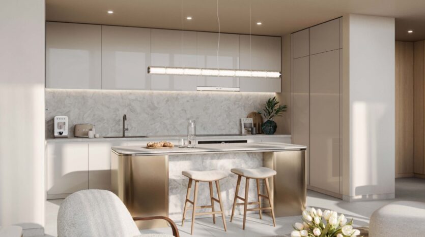 Современная кухня в Palm Central с белыми шкафами, мраморной заставкой и островком с двумя деревянными табуретами. Над островом висит линейный подвесной светильник, а декоративные предметы и техника аккуратно расставлены на прилавках.