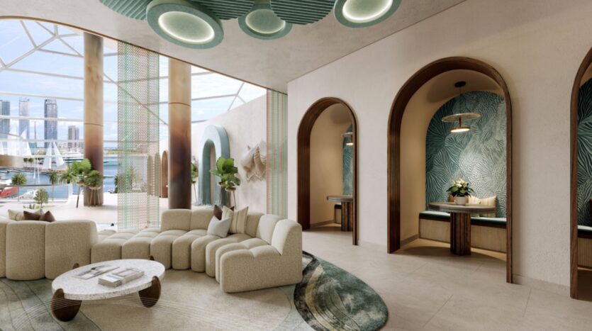 Salon moderne au Portside Square Mina Rashid avec des canapés crème incurvés, une table basse ronde, de grandes fenêtres et des plafonniers verts. Alcôves voûtées avec sièges, motifs muraux tropicaux et vue sur la ville ; le décor est composé de plantes et de tons naturels.