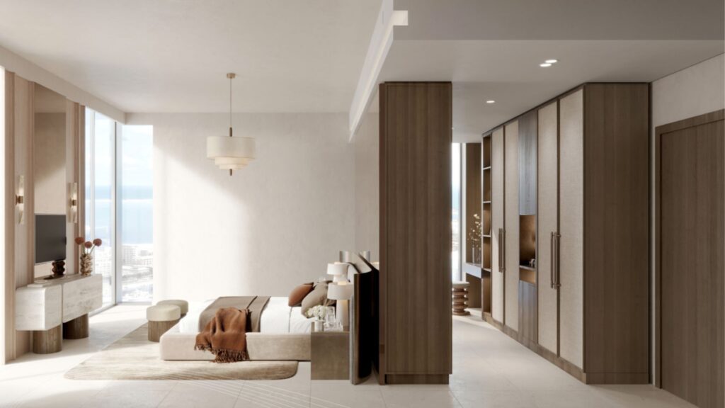 Salon moderne et minimaliste avec des tons neutres, un canapé beige, un jeté marron, une télévision, des armoires en bois encastrées et de grandes fenêtres offrant une vue sur l'océan et les bâtiments de la ville de Portside Square Mina Rashid à l'extérieur.