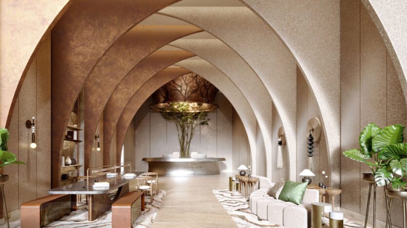 Le luxueux hall d'entrée de l'hôtel Portside Square Mina Rashid présente de hauts plafonds voûtés, un décor élégant et neutre, un mobilier moderne, des plantes en pot, un bureau de réception en marbre à l'arrière et un éclairage d'ambiance chaleureux.