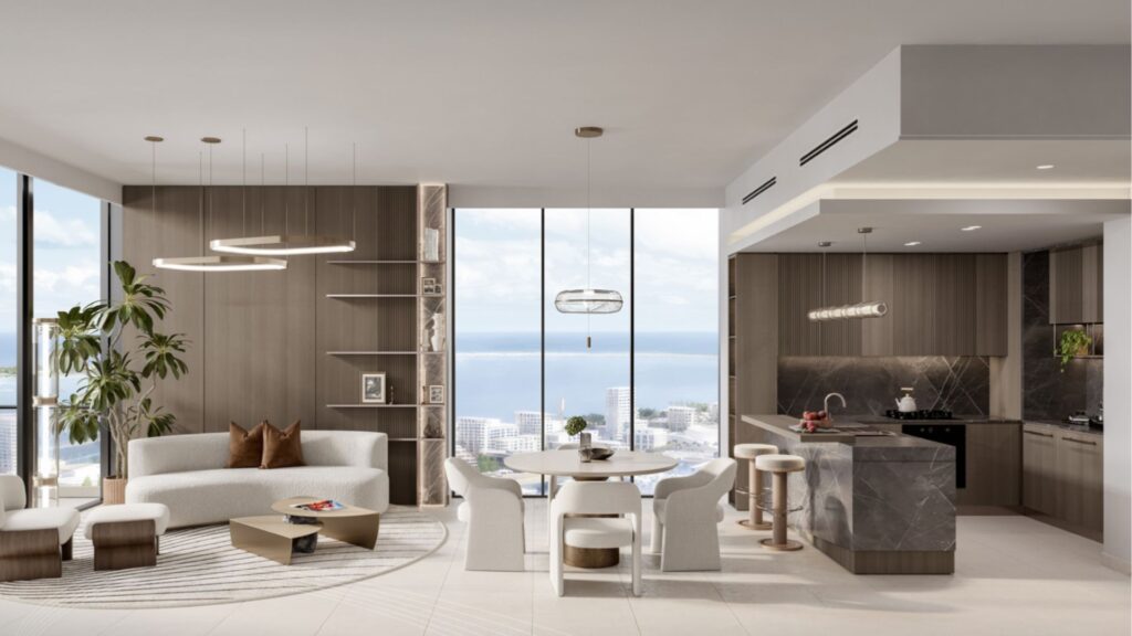 Salon et cuisine modernes à aire ouverte au Portside Square Mina Rashid, avec de grandes fenêtres, des tons neutres, un mobilier contemporain, une table à manger ronde, un îlot de cuisine en marbre et une vue imprenable sur la ville et l'océan à l'arrière-plan.