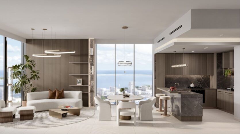 Salon et cuisine modernes à aire ouverte au Portside Square Mina Rashid, avec de grandes fenêtres, des tons neutres, un mobilier contemporain, une table à manger ronde, un îlot de cuisine en marbre et une vue imprenable sur la ville et l'océan à l'arrière-plan.