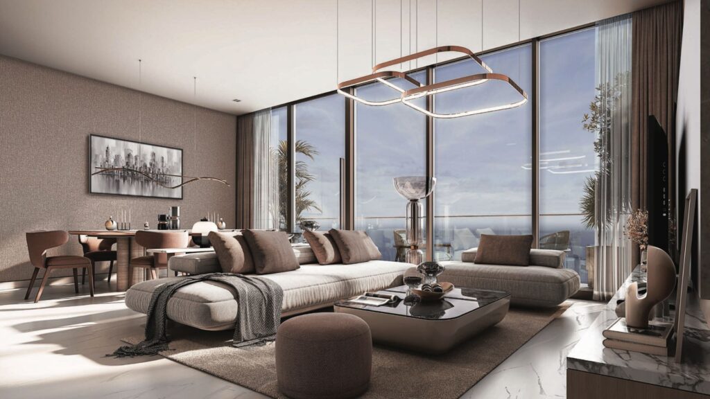 Modern living room with large floor-to-ceiling windows, neutral-colored furniture and elegant coffee table. Sunlight streams in, offering panoramic views of the SkyParks ocean from the dining room in the background.
