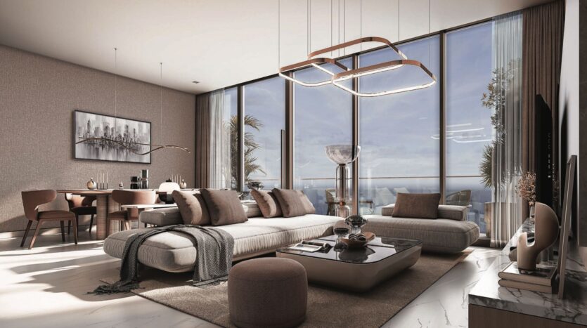 Modern living room with large floor-to-ceiling windows, neutral-colored furniture and elegant coffee table. Sunlight streams in, offering panoramic views of the SkyParks ocean from the dining room in the background.