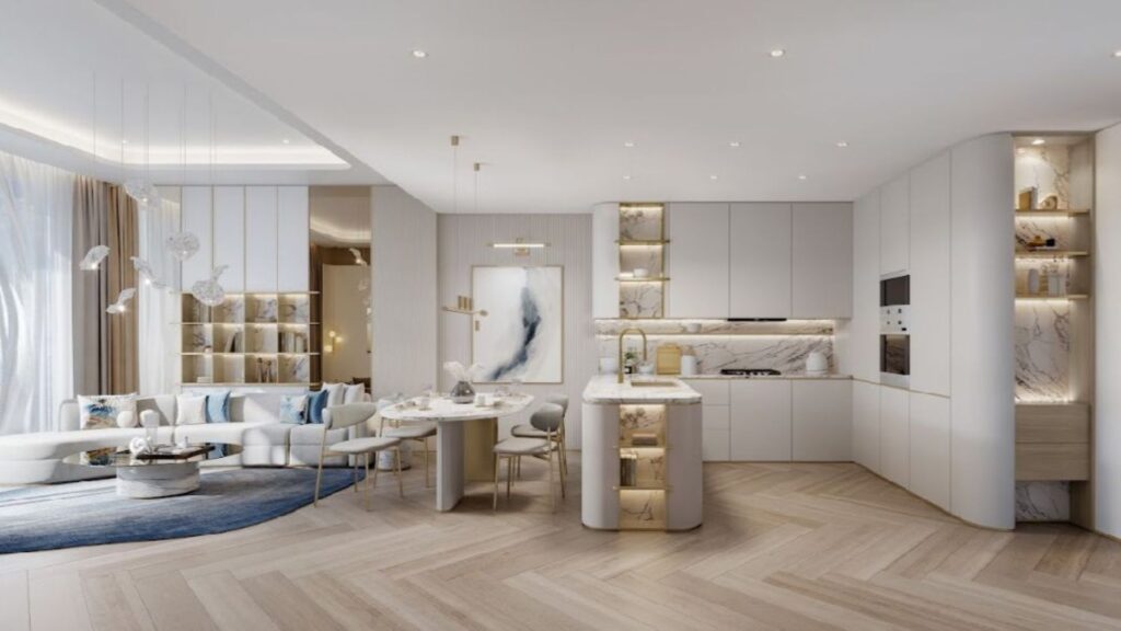 Cucina e soggiorno moderni nel Sunset Bay Grand Residence di Imtiaz a Dubai Islands, con toni chiari e neutri, tocchi di marmo, scaffali a muro, un comodo tavolo da pranzo rotondo, illuminazione elegante e ampie finestre con luce naturale.