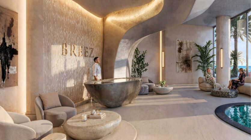 The hotel lobby is modern and elegant, with curved architecture, neutral tones, plush armchairs and a large sculptural desk. Danube Maritime City's lobby is adorned with potted plants and floor-to-ceiling windows offering breathtaking views of the ocean and palm trees.