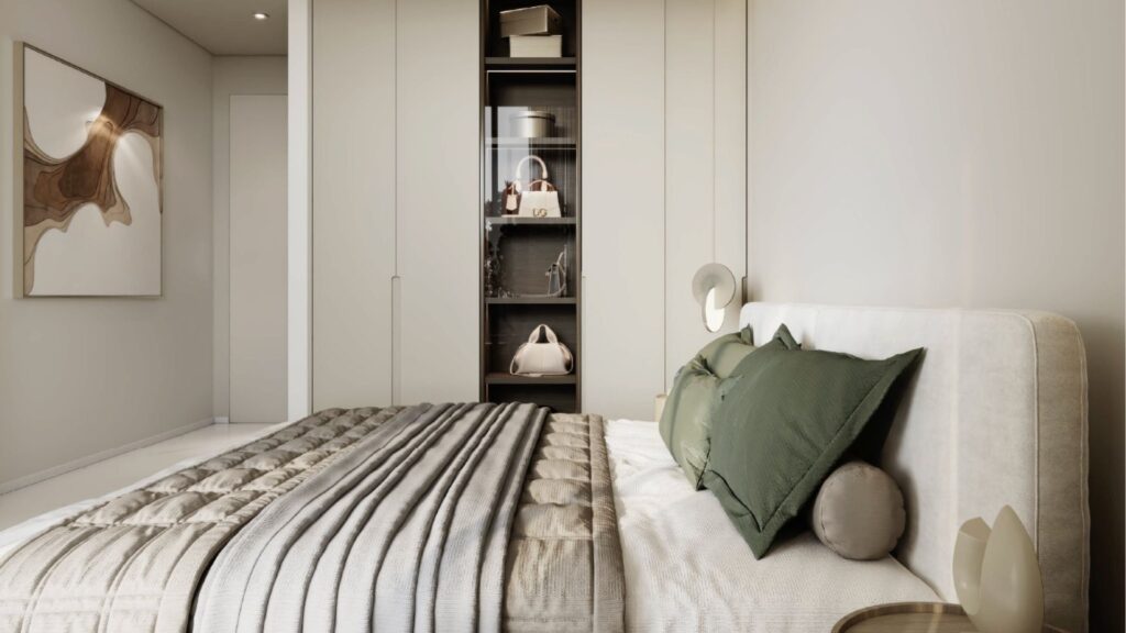 Une chambre à coucher moderne avec un lit soigneusement fait avec des oreillers verts et gris, une tête de lit rembourrée et une couette à rayures grises. Des placards encastrés et des étagères contenant des sacs et des objets de décoration évoquent le luxe de Franck Muller Yachting à Dubai Maritime City. Des œuvres d'art abstraites ornent le mur.