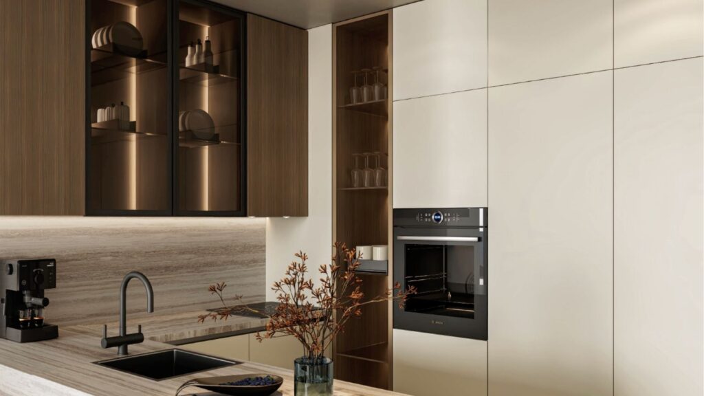 Cuisine moderne avec des armoires beige clair, un four encastré, des étagères en bois foncé, un évier et un robinet noirs, une machine à café et un vase avec des branches sur un comptoir clair - faisant écho à l'élégance de Franck Muller Yachting à Dubai Maritime City.
