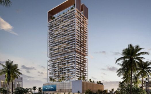 Una moderna torre con numerosos balcones y una terraza en la azotea se alza entre palmeras al atardecer en la Ciudad Marítima de Dubai. En la parte inferior aparece un letrero "YACHTING", que evoca la elegancia de Franck Muller Yachting en la Ciudad Marítima de Dubai. El cielo está parcialmente nublado.