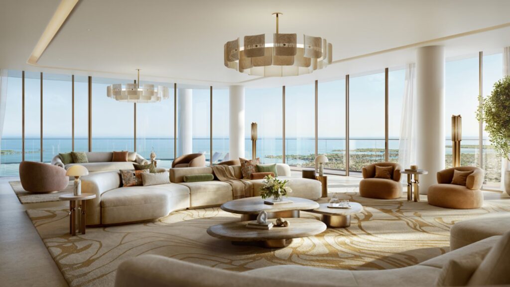 A spacious, modern Avarra lounge with large floor-to-ceiling windows, beige and cream furniture, round coffee tables, contemporary chandeliers and panoramic ocean views in the background.