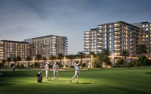 Three people play golf on the green hills of Golf Hills at dusk, with two modern multi-storey apartment buildings and palm trees in the background, all bathed in warm lights.