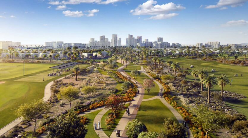 Un grande parco con sentieri, giardini, palme e persone che passeggiano. Sullo sfondo sono visibili gli edifici e lo skyline della città di Golf Hills, sotto un cielo azzurro punteggiato di nuvole.