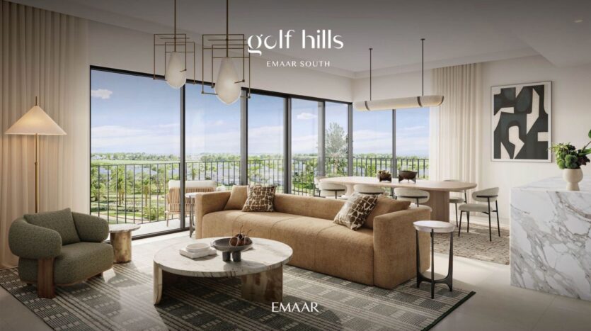 Un moderno soggiorno e sala da pranzo con ampie porte in vetro che si aprono su un balcone con vista sul verde di Golf Hills. L'ambiente è caratterizzato da mobili di tonalità neutra, opere d'arte astratte ed eleganti apparecchi di illuminazione. La scritta "Golf Hills EMAAR SOUTH" compare in alto.