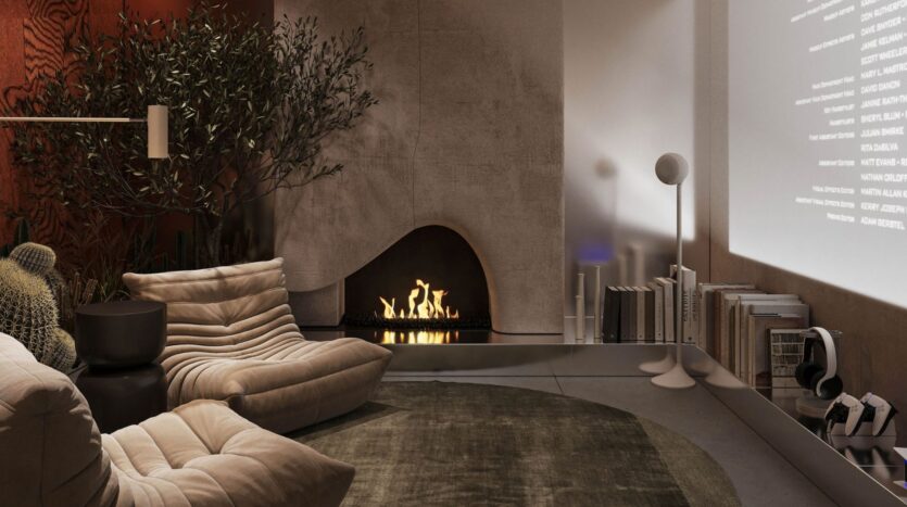 Rabdan Gardens' modern, comfortable living room features a curved fireplace, beige lounge chairs, a round green rug, bookcases, headphones and houseplants. Warm ambient lighting sets the mood, while a film is projected on the wall for relaxation.