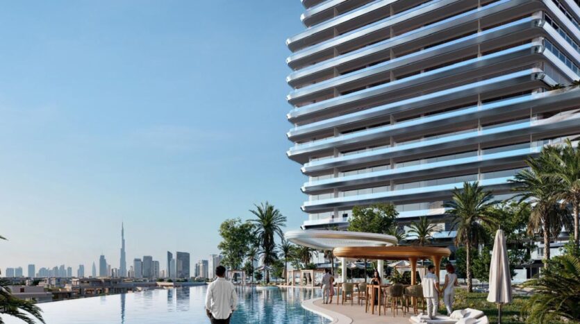 A person stands by an infinity pool with sun loungers, palm trees and parasols on elegant aerial terraces next to a modern high-rise building, with an urban skyline and a tall skyscraper visible in the background.