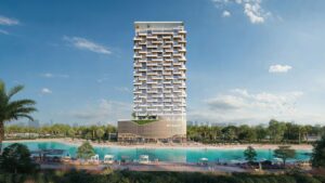 Il Caden è una grande torre moderna con una facciata geometrica unica che si erge sul bordo di una grande laguna turchese, circondata da palme, lettini e giardini paesaggistici sotto un cielo limpido e luminoso.
