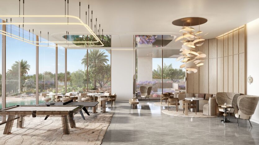 La moderna lounge di Caden con grandi finestre, tavolo da biliardo, illuminazione contemporanea, comodi posti a sedere, pavimenti in marmo e vista sulle palme e sulla piscina esterna, in un giardino lussureggiante.