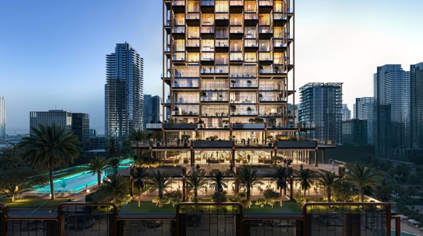 The Symphony is a modern high-rise building with illuminated balconies, surrounded by palm trees and greenery. A swimming pool and outdoor relaxation areas are visible, with other skyscrapers in the background at dusk.