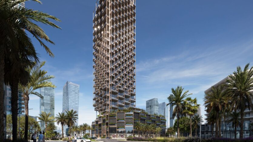 The Symphony, a large modern skyscraper with a unique geometric facade, stands amid palm trees and smaller buildings, against a clear blue sky and surrounded by other high-rise structures in an urban area.