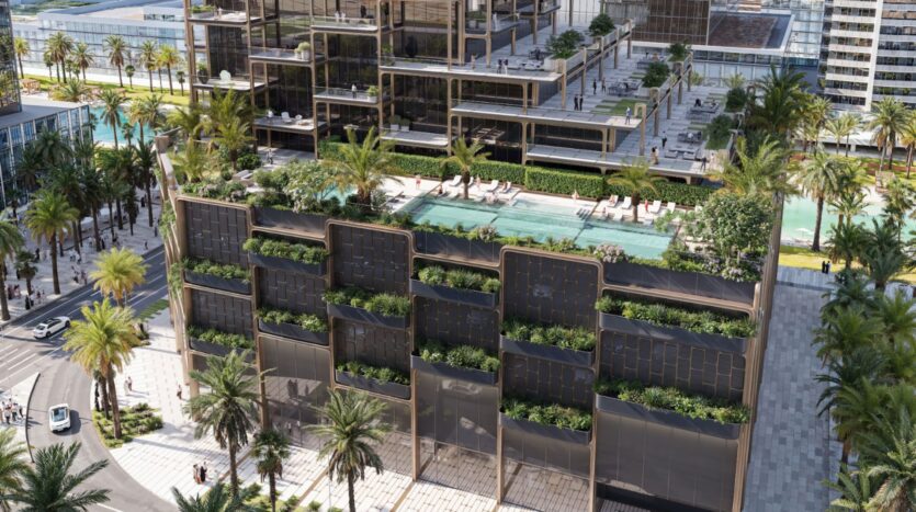 The Symphony is a modern multi-story building with rooftop pools, lush green spaces, and outdoor seating, surrounded by palm trees and bustling city streets, seen from above during the day.